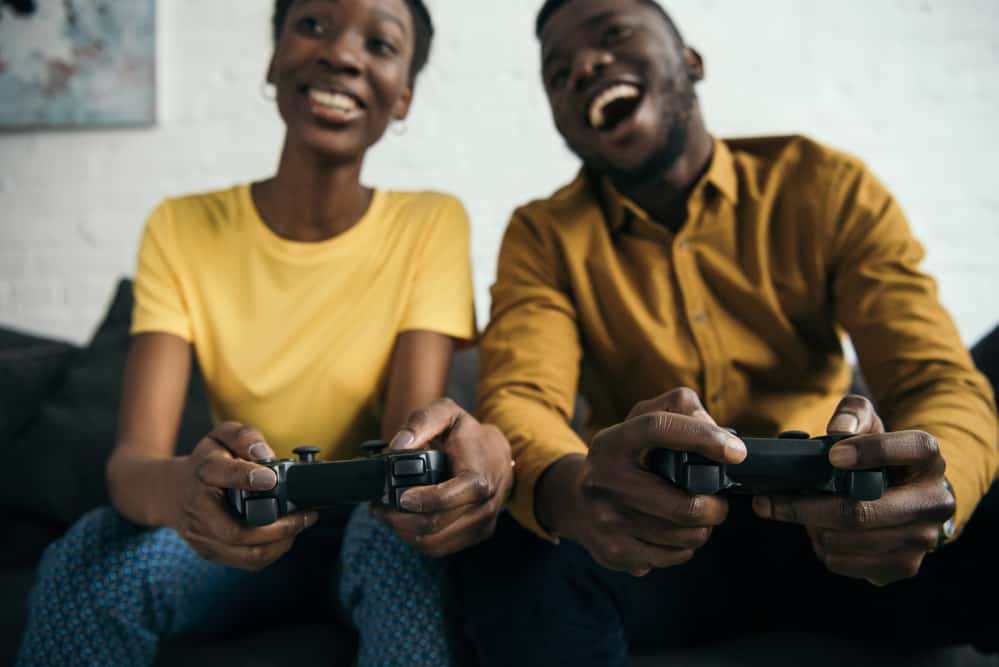 Two people laughing and holding video game controllers, enjoying games from Mario to Master Chief.